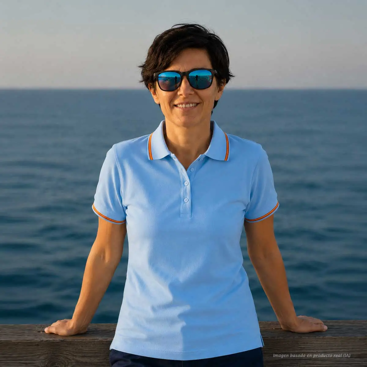 Vista frontal de polo celeste mujer con bandera de España en cuello y mangas