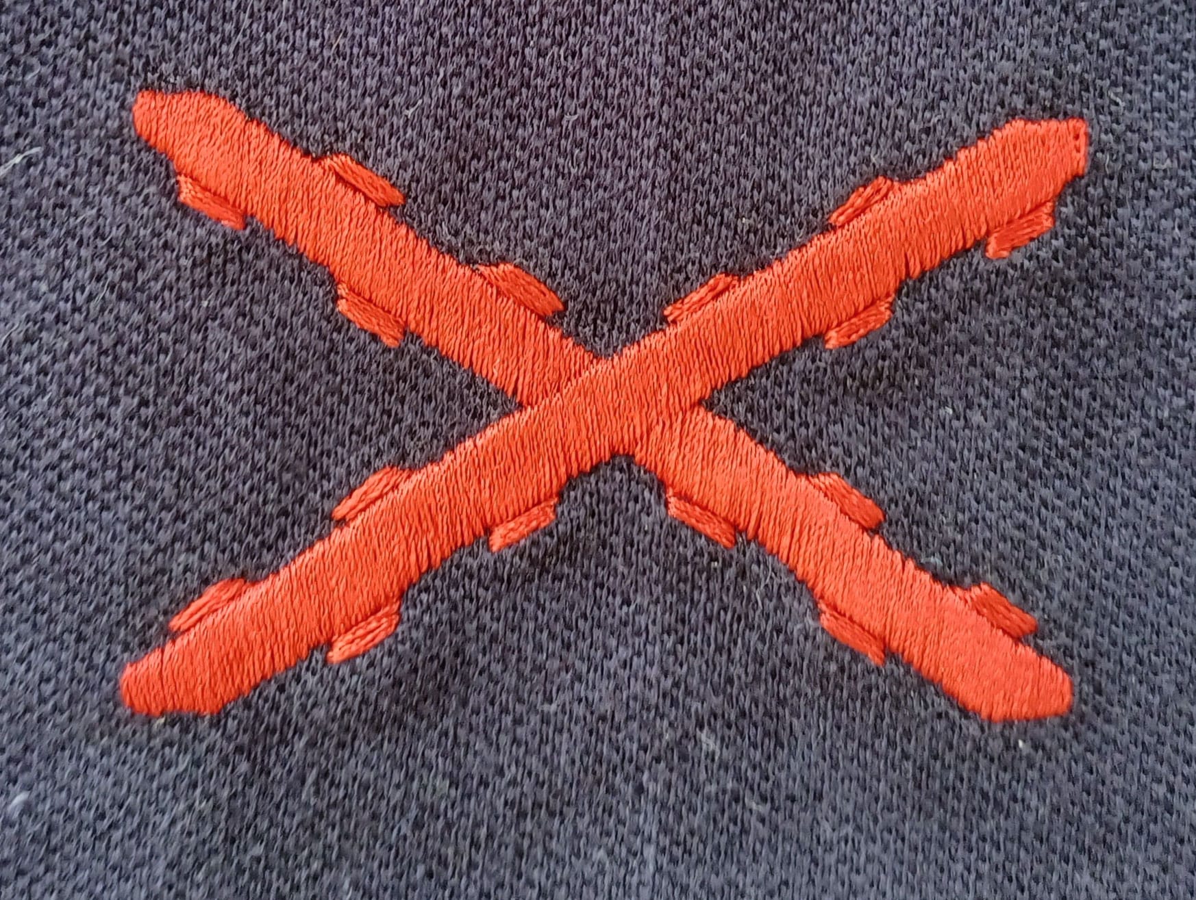 Detalle del bordado de la Cruz de Borgoña en polo marino